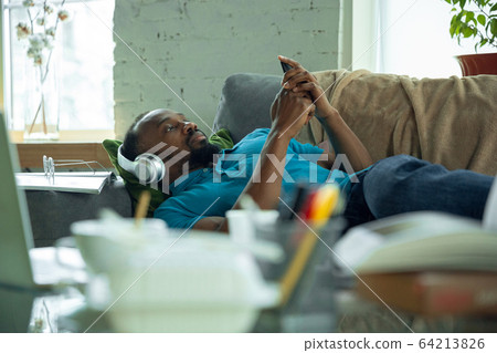 African-american man staying at home during quarantine because of coronavirus spreading African-american man staying at home during quarantine because of coronavirus spreading 64213826