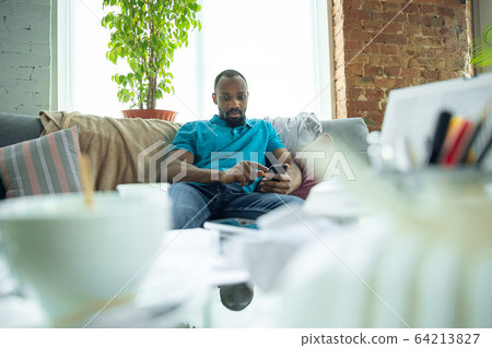 African-american man staying at home during quarantine because of coronavirus spreading 64213827