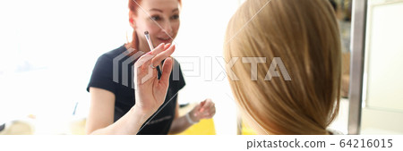 Cheerful young woman working with blonde lady 64216015