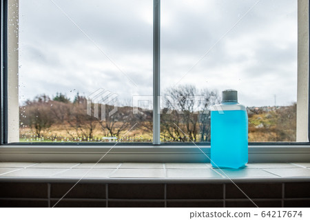 Desinfection liquide botte standing at home during pandemia 64217674