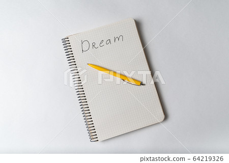 Top view of notepad with inscription Dream and Top view of notepad with inscription Dream and 64219326