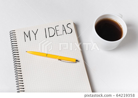 Notepad with inscription MY IDEAS. Pen and cup of Notepad with inscription MY IDEAS. Pen and cup of 64219358