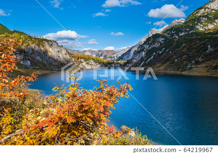 Sunny autumn alpine Tappenkarsee lake and rocky mountains above, Kleinarl, Land Salzburg, Austria. Sunny autumn alpine Tappenkarsee lake and rocky mountains above, Kleinarl, Land Salzburg, Austria. 64219967