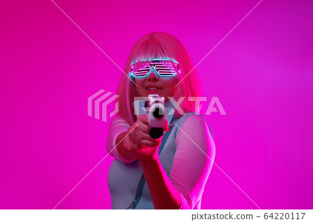 Girl with blaster in the futuristic battle. Concept virtual reality, cyber game. Girl with blaster in the futuristic battle. Concept virtual reality, cyber game. 64220117