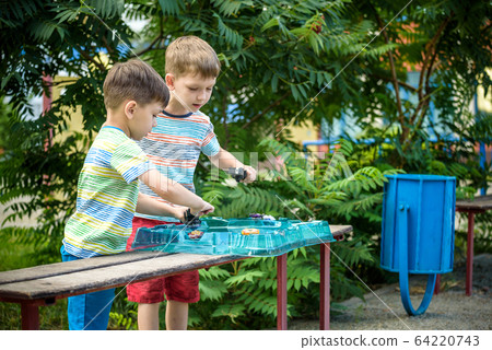 Two boys playing with a spinning top kid toy. 64220743