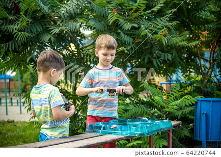 Two boys playing with a spinning top kid toy. Two boys playing with a spinning top kid toy. 64220744