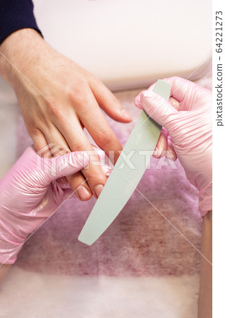 Close-up Of A Manicurist Filing Person's Nails In Salon 64221273