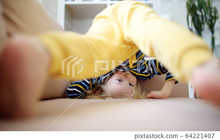 Little boy is standing on own head on sofa at home Little boy is standing on own head on sofa at home 64221407