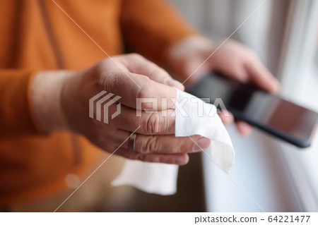 Mature man wipes with a disinfecting cloth heis Mature man wipes with a disinfecting cloth heis 64221477