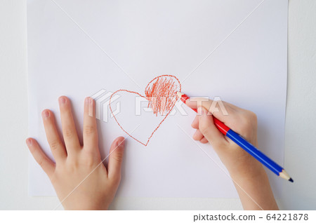 Children's hands on a white background draw a red heart.A declaration of love and friendship. Gratitude to loved ones. 64221878