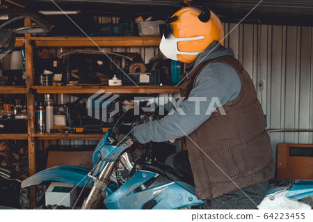 Emoji motocross rider with fancy black nerd sunglasses on his motorcycle inside of garage . Emoji with mask protecting against coronavirus Covid 19. 3D rendering and photography collage. Emoji motocross rider with fancy black nerd sunglasses on his motorcycle inside of garage . Emoji with mask protecting against coronavirus Covid 19. 3D rendering and photography collage. 64223455
