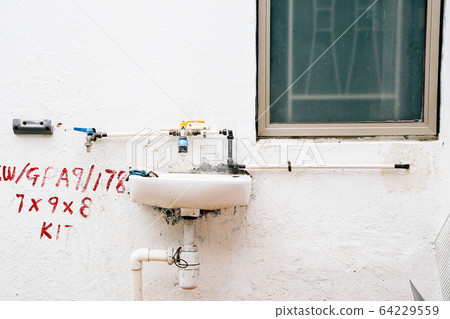Old washstand on white wall in HongKong Old washstand on white wall in HongKong 64229559