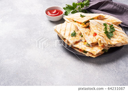 Triangular slices of a Mexican quesadilla with the Triangular slices of a Mexican quesadilla with the 64231087