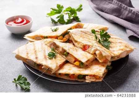 Triangular slices of a Mexican quesadilla with the Triangular slices of a Mexican quesadilla with the 64231088