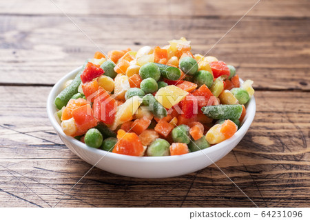 Chopped frozen vegetables in a plate on a wooden 64231096