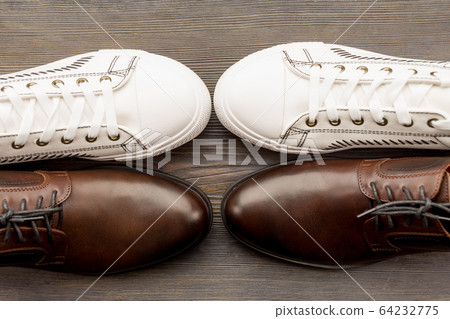 Men's classic brown shoes and white sneakers on a Men's classic brown shoes and white sneakers on a 64232775