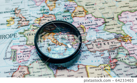 Inspecting of a world map atlas and looking at various countries and continents Inspecting of a world map atlas and looking at various countries and continents 64233403
