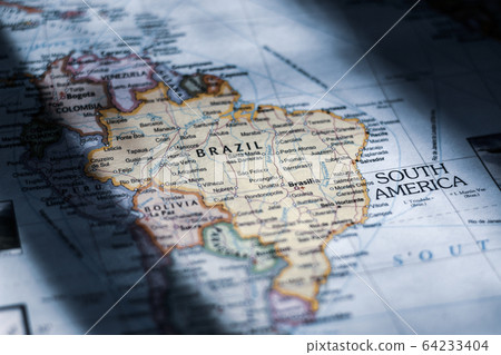 Inspecting of a world map atlas and looking at various countries and continents Inspecting of a world map atlas and looking at various countries and continents 64233404