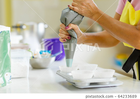 Woman professional pastry chef spreads chocolate Woman professional pastry chef spreads chocolate 64233689