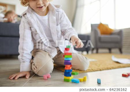 Child playing with colored blocks 64236162