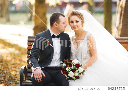 Romantic wedding moment, couple of newlyweds smiling portrait, bride and groom hugging 64237715