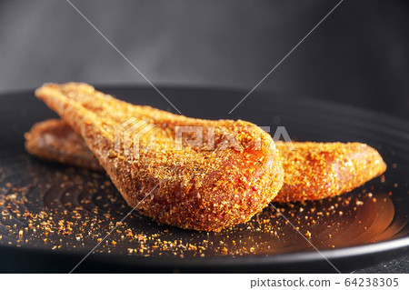 Seasoned chicken with hot sauce and a sprig of rosemary Seasoned chicken with hot sauce and a sprig of rosemary 64238305