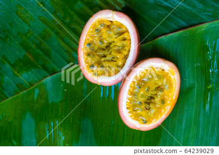 Ripe passion fruit, on a wet banana leaf. Ripe passion fruit, on a wet banana leaf. 64239029