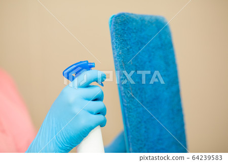 Women hand in a blue rubber glove in the picture, removes and washes bathroom sink by spray and sponge, hygiene concept 64239583