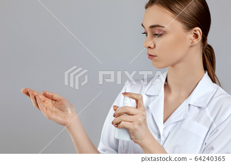 woman doctor in white uniform using sanitizer dispenser 64240365