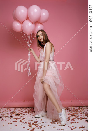 fashion model woman in dress holding pastel pink air balloons fashion model woman in dress holding pastel pink air balloons 64240392