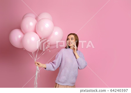 birthday girl posing with balloons 64240397