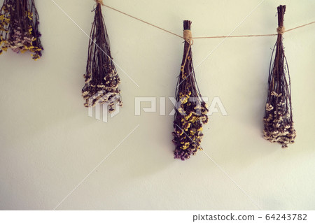 bouquet of dried flowers hanging on rope against 64243782