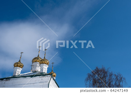 Golden domes with crosses of a white stone church Golden domes with crosses of a white stone church 64247149