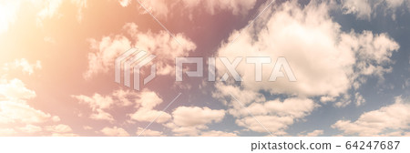 Beautiful landscape of blue cloudy sky with warm sunny tonings. Warm and soft sunlight illuminate sky. Ultra-wide panoramic natural background Beautiful landscape of blue cloudy sky with warm sunny tonings. Warm and soft sunlight illuminate sky. Ultra-wide panoramic natural background 64247687
