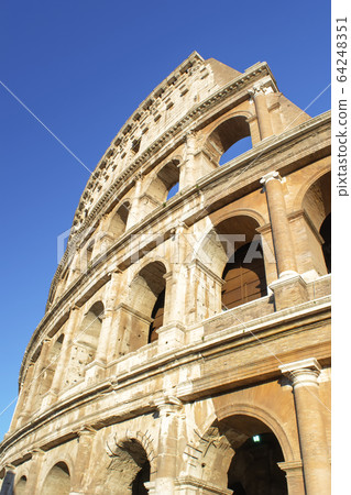 Part of Rome Colosseum at blue sky. Vertical image 64248351