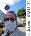 Man in city street wearing face mask protective for spreading of Coronavirus Disease. Portrait of man with surgical mask on face against SARS-CoV-2 64248439
