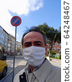 Man in city street wearing face mask protective for spreading of Coronavirus Disease. Portrait of man with surgical mask on face against SARS-CoV-2 64248467
