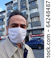 Man in city street wearing face mask protective for spreading of Coronavirus Disease. Portrait of man with surgical mask on face against SARS-CoV-2 64248487