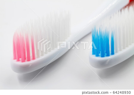 New red and blue plastic toothbrushes on white New red and blue plastic toothbrushes on white 64248930