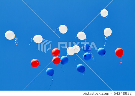 Multicolored helium balloons flying up in the blue Multicolored helium balloons flying up in the blue 64248932