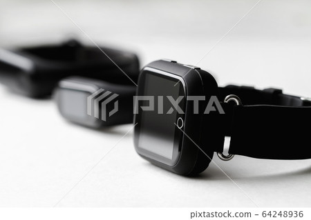 A row of fitness trackers and smart watch on white A row of fitness trackers and smart watch on white 64248936