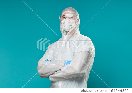 Man in protective suit, medical mask, goggles with arms crossed. Man in protective suit, medical mask, goggles with arms crossed. 64249891