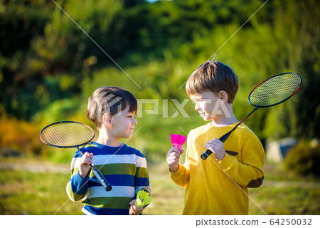 Active preschool girl and boy playing badminton in 64250032