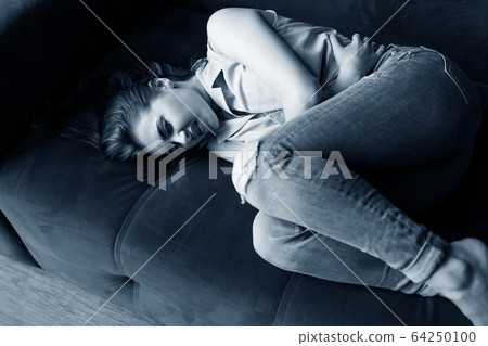 Beautiful young woman feels menstruation pain and anger. Beautiful young woman feels menstruation pain and anger. 64250100