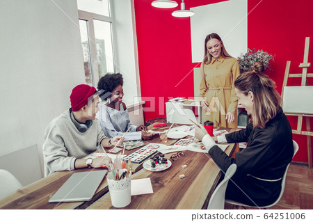 Positive delighted tutor talking to her students Positive delighted tutor talking to her students 64251006