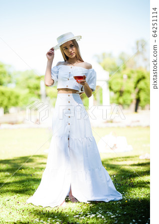 Portrait of happy young woman having rest on picnic in park Portrait of happy young woman having rest on picnic in park 64251114