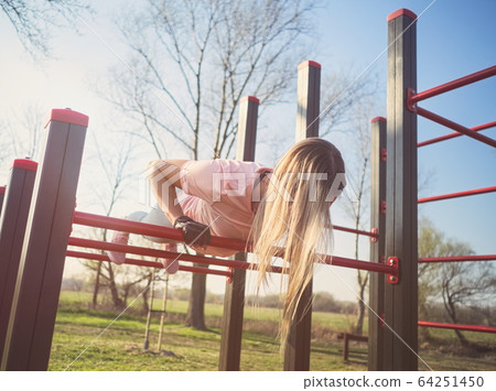 Woman Doing Push Ups in the Park 64251450