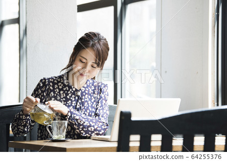 A young woman poured herbal tea 64255376