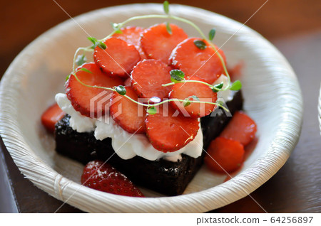 chocolate cake or brownie with strawberry topping 64256897