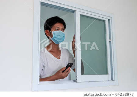 Man in isolation at home for coronavirus outbreak 64258975